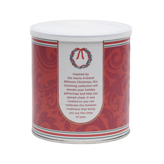 A cylindrical metal canister with a white lid, featuring a red and white holiday-themed label with text about A Grand Biltmore Christmas.