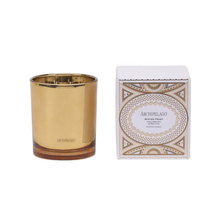 A gold candle and its white packaging box are shown next to each other on a white background. The front of the box has product information and a gold design. 