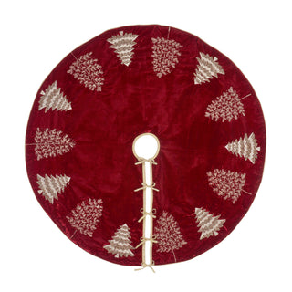 A round red velvet Christmas tree skirt with embroidered silver pine trees and a central hole with decorative tie-on cords, shown on a white background.