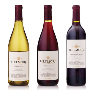 Three Biltmore Winery wine bottles on a white background: Chardonnay with pale yellow wine, Pinot Noir with deep red wine, and Cabernet Sauvignon with very dark purple wine.