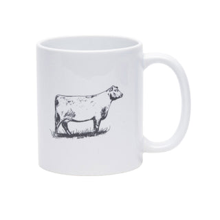A white ceramic mug featuring a black line-art sketch of a cow standing on grass, shown against a plain white background.
