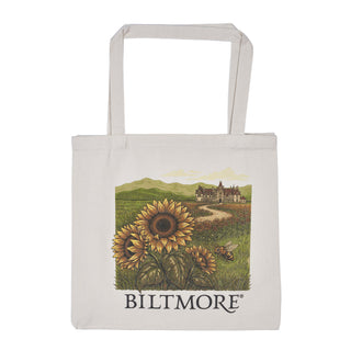 A natural canvas tote bag with a printed illustration of sunflowers, a bee, a country road, and a castle in the distance, with the word 'BILTMORE' printed below the artwork.
